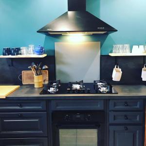 a kitchen with a black counter top with a stove at Domaine des Pins in Cast