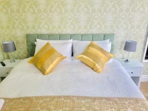 een bed met 2 gele kussens en 2 lampen bij Highlea Guest House in Weston-super-Mare