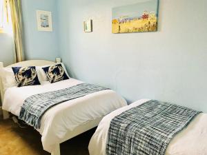 una camera con due letti e una foto a parete di Highlea Guest House a Weston-super-Mare