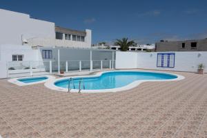 a swimming pool in the middle of a patio at Maximilian House-Duplex vista al mar en complejo con piscina in Puerto del Carmen