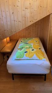 a bed in a room with a wooden wall at Ferienwohnung am Süd-Schwarzwald 1 in Murg