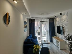 a living room with a blue couch and a window at Haven Apart 2 in Jelenia Góra