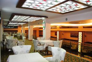 フェティエにあるMalahit Exclusive City Hotelの天井のレストラン(白いテーブルと椅子付)