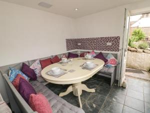 a dining room with a table and purple pillows at Roseville in Matlock