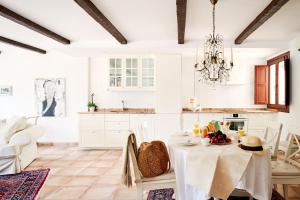 a white kitchen with a table and a chandelier at Balcon de Europa in Nerja