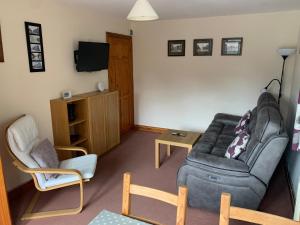 Mallows Cottage في شيربورن: غرفة معيشة مع أريكة وكرسي