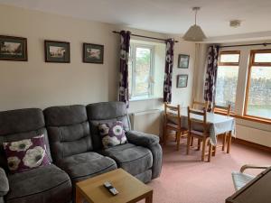 a living room with a couch and a table at Mallows Cottage in Sherborne