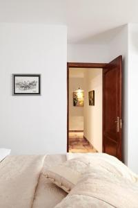 Dormitorio blanco con cama y puerta de madera en Balcon de Europa en Nerja