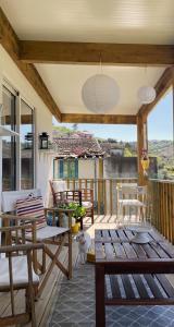 una veranda con tavoli e sedie in legno su una casa di My Grandmas A casa das avós a Vale de Figueira