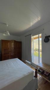 una camera da letto con un grande letto bianco e una finestra di My Grandmas A casa das avós a Vale de Figueira