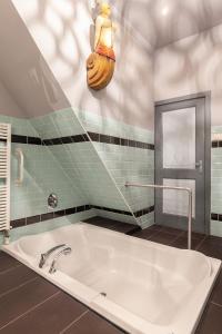 e bagno con vasca e lavandino. di De Kapiteinshut aan de rivier met XL ligbad en sauna a Lekkerkerk