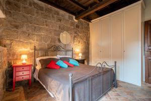 a bedroom with a bed and a stone wall at La Suite del Borgo in Viterbo
