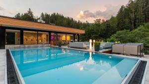 a swimming pool in front of a house at Sackmann Schwarzwald Charme in Baiersbronn