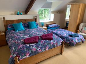 a bedroom with two beds with blue pillows at Mallows Cottage in Sherborne