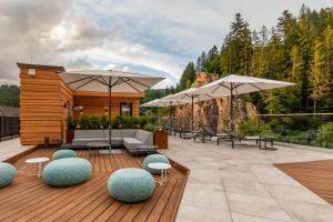 a patio with umbrellas and furniture on a deck at Sackmann Schwarzwald Charme in Baiersbronn