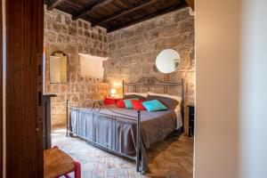 ein Schlafzimmer mit einem Bett in einer Steinmauer in der Unterkunft La Suite del Borgo in Viterbo