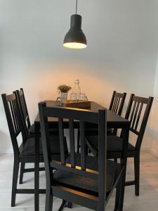 a black dining room table with chairs and a lamp at Modernes Business Apartment für Geschäftsreisende, Monteure, Handwerker in Burgneudorf