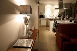 een woonkamer met een bank en een tafel met een lamp bij Le Porche de Sarlat in Sarlat-la-Canéda