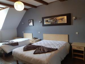 a bedroom with two beds and a picture on the wall at A l'étoile d'or in Batzendorf
