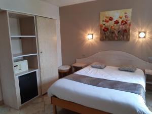 a bedroom with a bed and a painting on the wall at A l'étoile d'or in Batzendorf