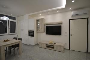 a living room with a table and a tv on the wall at Houses & Rooftop Pompei - Sky in Pompei