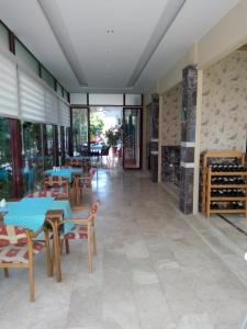 un restaurante con mesas, sillas y ventanas en Sailor Apart Hotel, en Alanya