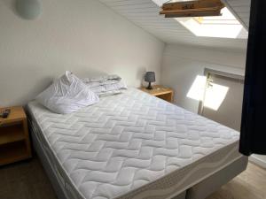 サン・ジュリアン・アン・ボルヌにあるMaison - Village Océlandesの天井の客室の大きな白いベッド1台