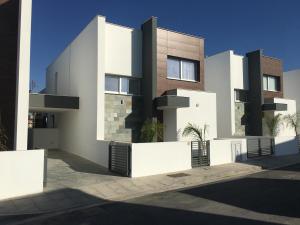 een wit gebouw met een hek ervoor bij Mobina Villas in Larnaka