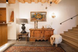 a living room with a dog standing next to a dresser at Jochum Hotel Garni in Fiss