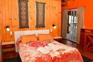 a bedroom with a bed with two towels on it at Milagros de Montaña in Villa Pehuenia