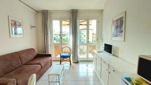- un salon avec un canapé et une télévision dans l'établissement Foscolo POOL apartment, à Bardolino