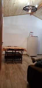 a living room with a table and a refrigerator at Cabana da Montanha - Sítio Pasangas in Santo Antônio do Pinhal