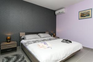 - une chambre avec un grand lit et des draps blancs dans l'établissement Apartment Lapad Bay, à Dubrovnik