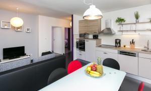 a kitchen with a table with a bowl of fruit on it at Lapad Bay Apartman - Black in Dubrovnik