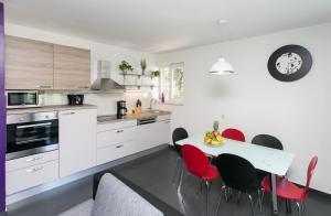 a kitchen with a table and red chairs at Apartment Lapad Bay in Dubrovnik