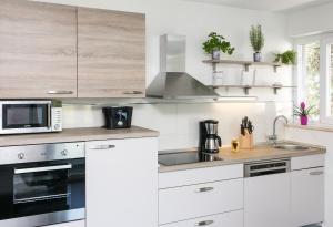 a white kitchen with a sink and a microwave at Lapad Bay Apartman - Black in Dubrovnik +6 photos