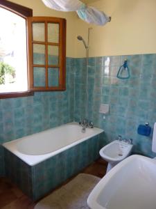 a bathroom with a tub and a toilet and a sink at Appartement Rez de Jardin in Luz-Saint-Sauveur