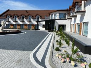 un bâtiment avec une cour avec des plantes devant lui dans l'établissement Hotel Sebory, à Przasnysz