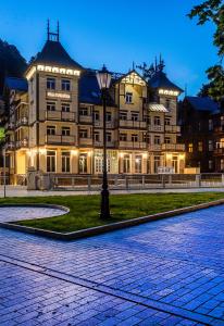 a large building with a street light in front of it at Hotel Willa Tatrzańska in Krynica Zdrój