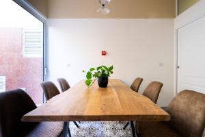 a dining room table with chairs and a potted plant at Lady Todd in Sliema