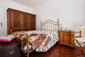sypialnia z łóżkiem i drewnianą komodą w obiekcie Cister House w mieście Alcobaça