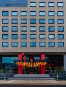 una persona in piedi di fronte a un hotel di Radisson RED Hotel Johannesburg Rosebank a Johannesburg