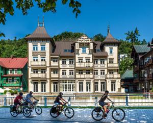 un grupo de personas montando bicicletas delante de un edificio en Hotel Willa Tatrzańska, en Krynica-Zdrój