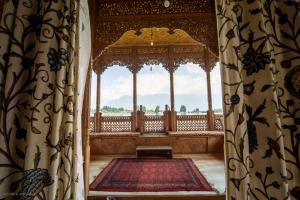 a room with a large window with a rug in it at Khilona luxury Heritage Houseboats in Srinagar