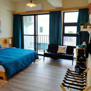 a bedroom with a bed and a couch and windows at Lao Yu Homestay in Taitung City