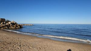 una persona parada en una playa cerca del agua en Habitaciones de Hostal a Primera linea de playa en Cullera, en Cullera