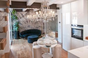 ca' squero911 luxury rooms في تشيزيناتيكو: غرفة طعام مع طاولة وثريا