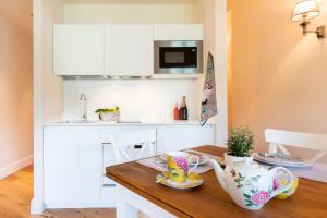 a small kitchen with a wooden table with tea cups at Isola Bella Apartments Via Vittorio Emanuele in Stresa