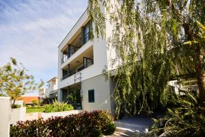 a white building with trees in front of it at Villa Grdelina in Supetar