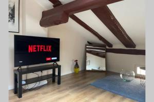 sala de estar con TV de pantalla plana sobre una mesa en portanova attic en Bolonia